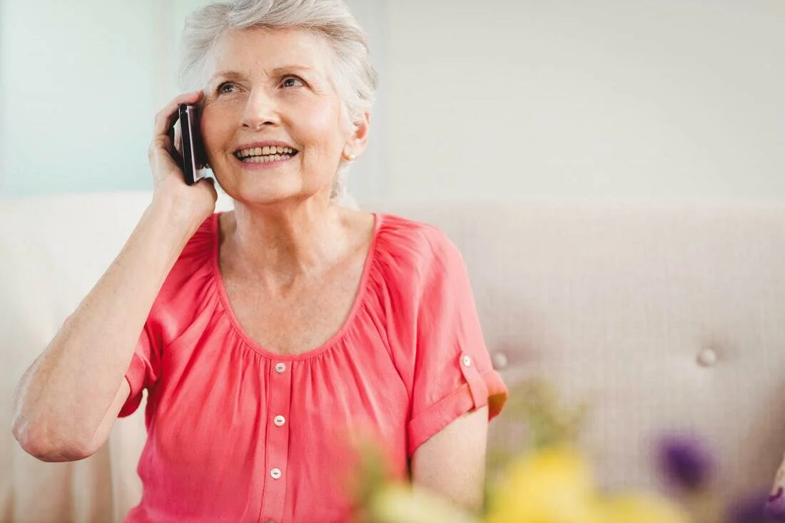 elder woman smiling taking phone call